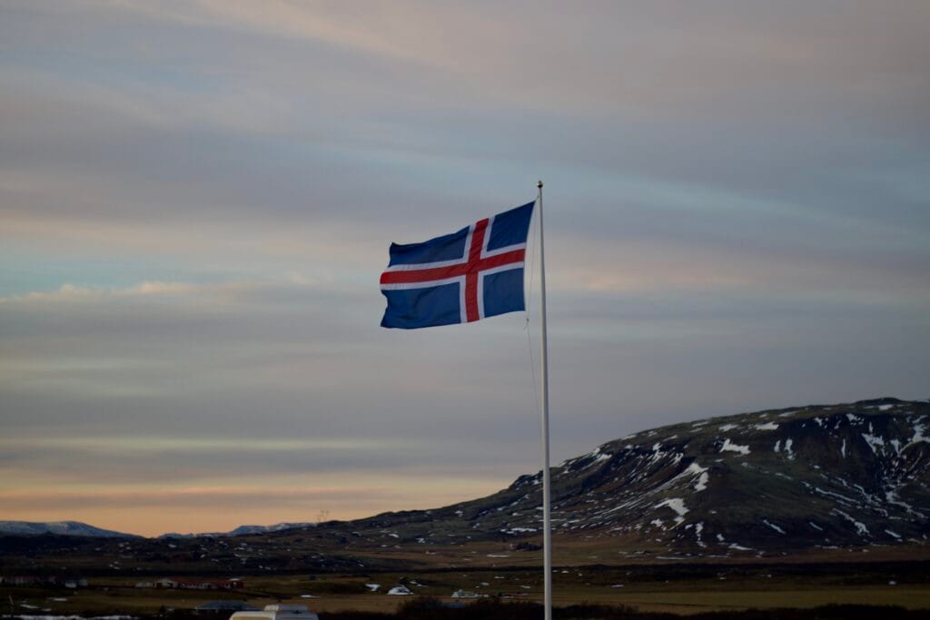 Photo of Iceland flag blowing in the wind above Kerid Crater