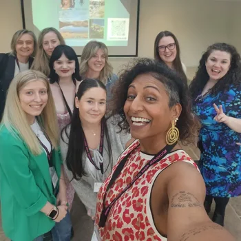 Sukanya, host of Sukany4 – The Podcast, smiling with eight women at an International Women’s Day event in Cumbria, celebrating community, creativity, and connection